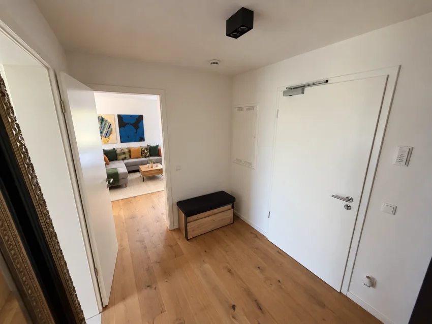 Entrance hall with bench, front door and view into the living room