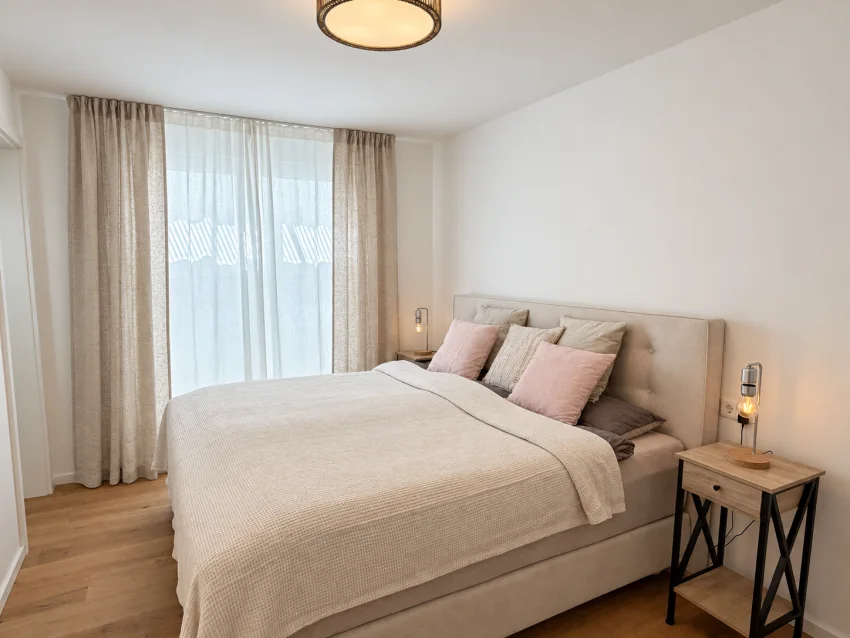 Lower-ground bedroom with a large bed and light textiles