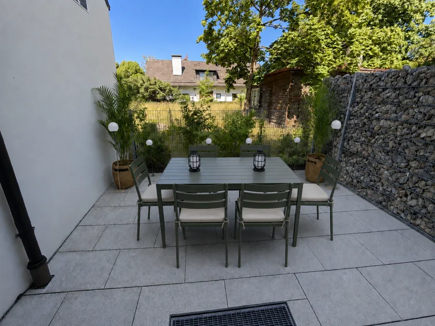 Terrace with a table set for six overlooking the green garden