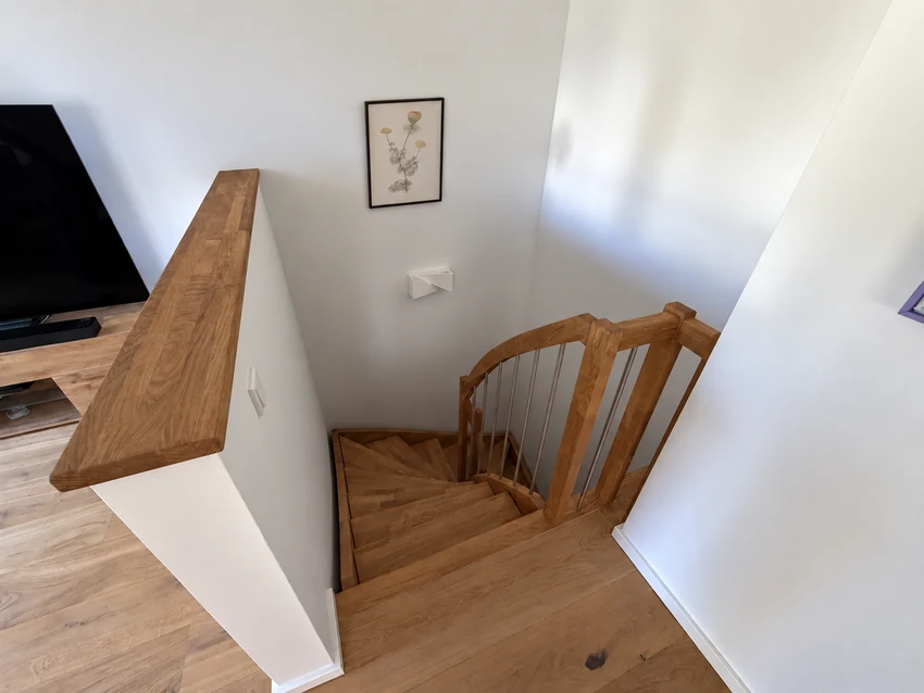 Internal wooden staircase with a framed botanical print